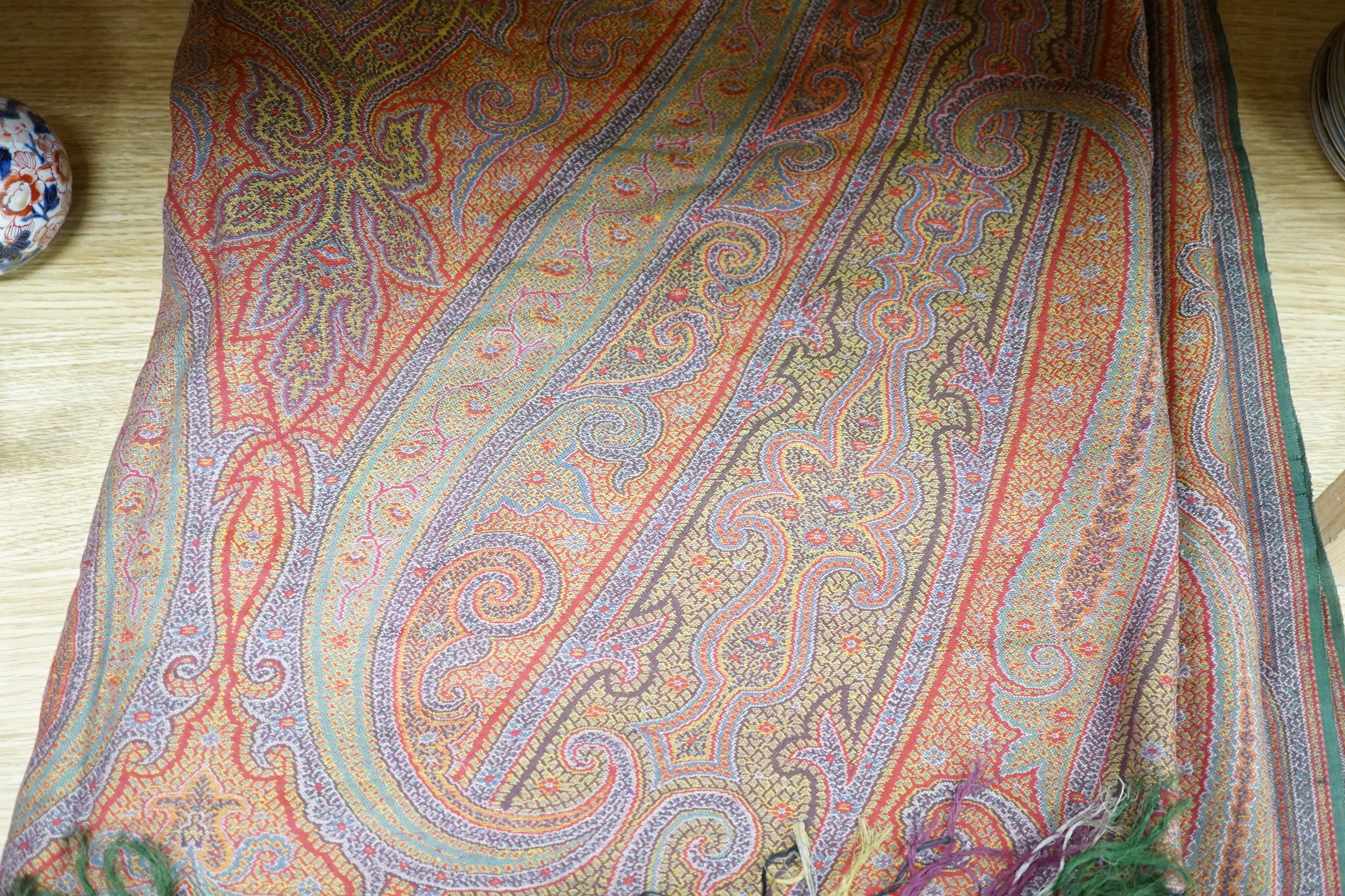 A 19th century woven multi coloured wool and silk Paisley shawl, with large all over paisley tear drop design and brightly coloured fringed borders, 335cm long x 166cm wide